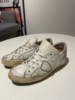 Phillipe models - Hej! Säljer dessa slitna phillipe modelsen. 🙌Skorna är créme-vita med snygga detaljer. Storleken är 39. Pris diskuteras. Har använt dem under en lång period, och därför är dem så slitna. Sulan är sprucken o och det yttre lagret håller inte sitt skick. Skriv vid några som helst frågor eller funderingar!🙌😊Mvh, Milo. 