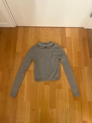 Grå ribbad polotröja Forever 21 - Säljer en grå ribbad polotröja från Forever 21 i storlek S. Tröjan har lång ärm. Perfekt att styla med jeans eller kjol för en chill look. 