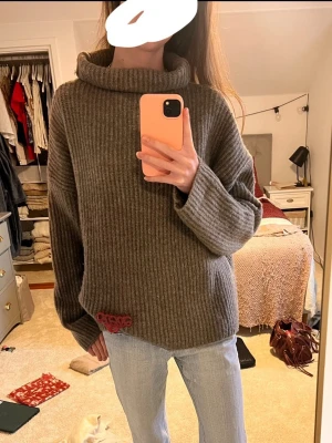 Beige/brun  ribbad polotröja  - Mysig beige polotröja med bred krage och ribbad struktur. Tröjan är stickad  och har en loose passform med långa ärmar. Perfekt för kyliga dagar och enkel att styla med jeans eller kjol. Storlek m men passar även s!