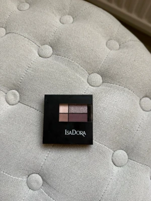 IsaDora ögonskuggspalett Chic Neutrals - IsaDora Eyeshadow Quartet 08 Chic Neutrals med fyra nyanser: ljus champagne, skimrande taupe, varm brun och matt plommonlila. Aldrig använd. 