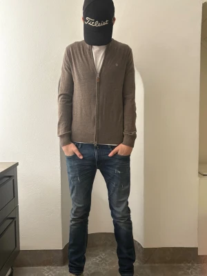 Brun kofta från Morris i merinoull - Säljer en stilren brun kofta från Morris i storlek S, tillverkad i 100% merinoull. Koftan har dragkedja framtill, ribbade muddar och en diskret logga på bröstet. Perfekt för dig som gillar klassisk och enkel design. Perfekt kofta med unik färg till billigt pris. Original pris 1499 jag säljer den endast för 649 riksdaler. Den är bara använd ett fåtal gånger. Hör av dig vid funderingar 👌🏻