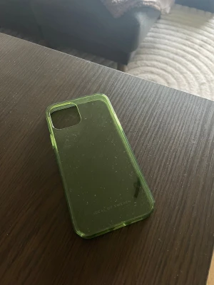 Helt nytt mobilskal till iPhone 12 - Helt nytt grönt mobilskal till iPhone 12, skalet är genomskinligt och det är köpt hos Ideal of Sweden.