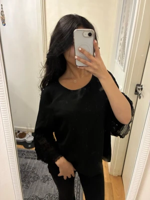 Svart blus med spetsärmar - Säljer en svart blus med vida ärmar och snygga spetsdetaljer längst ner på ärmarna. Storlek M men sitter som S. 