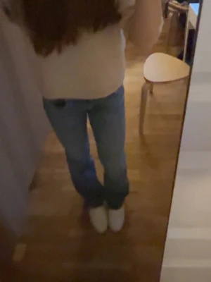 Blå  jeans med låg midja - Säljer ett par klassiska blå jeans med bootcut-snitt och normal passform. Jeansen har en snygg ljusblå tvätt och är tillverkade i jeansmaterial. Perfekta för dig som gillar en avslappnad och tidlös stil.