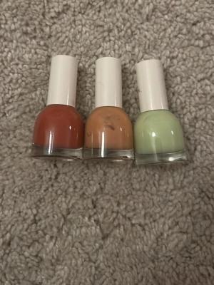 3-pack nagellack från H&M i trendiga färger - Säljer tre nagellack från H&M i snygga färger: ett tegelrött, ett persikoorange och ett ljusgrönt. Flaskorna är runda med vita lock och rymmer 8 ml vardera. Perfekt för dig som vill variera din nagellook med fräscha nyanser.