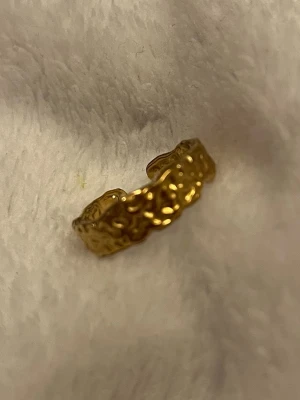 Guldfärgad ring ✨ snygg design | justerbar          - Superfin guldfärgad ring med organisk, strukturerad design ✨ En stilren men trendig ring som passar perfekt både till vardag och fest. Öppen modell vilket gör den lätt justerbar i storlek. ✨ Minimalistisk & trendig ✨ Justerbar passform ✨ Perfekt att bära ensam eller stacka med andra ringar I mycket fint skick 🤍 Skickas snabbt 📦 Skriv gärna om du vill ha fler bilder!