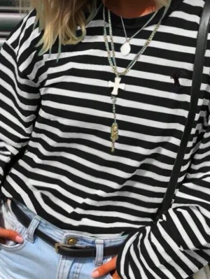 Randig långärmad topp  - Säljer en svartvit randig långärmad topp med rund halsringning och diskret logga broderad på bröstet. Perfekt till jeans eller kjol för en avslappnad men ändå stilsäker look.