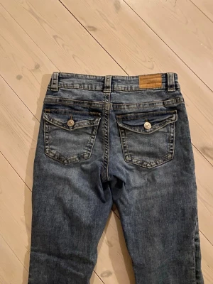 Blå bootcut jeans med ficklock - Snygga blå jeans med bootcut med fickor där bak säljer för att dom var förstora när jag köpte dom men kan tyvärr inte skicka till baka! Ordinarie pris 500