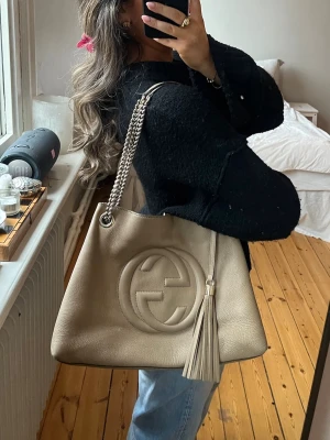 Gucci Soho väska - Intressekoll på min Gucci Soho väska i beige. Mått: Gucci soho bag medium i färgen beige. Mått: bredd 37cm, höjd 28cm, djup: 14cm. Äkthetsbevis medföljer. Köpt för 8000kr. 