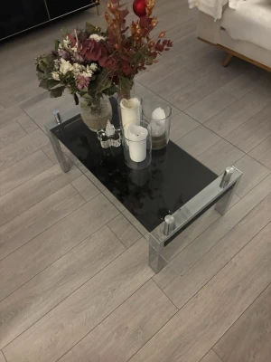 Stilrent soffbord i glas – nyskick - Säljer ett mycket fint och modernt soffbord i glas med kromade ben, köpt helt nytt från Chilli för 3 500 kr. Bordet är endast 4 månader gammalt och i princip helt nytt/nyskick, utan repor eller skador.  Anledningen till försäljningen är ommöblering – bordet passar tyvärr inte längre in i nuvarande inredning.  Säljs för 2 500 kr, pris kan diskuteras vid snabb och smidig affär. Ett perfekt soffbord för dig som vill ha ett stilrent, stabilt och exklusivt bord till ett riktigt bra pris.  Hör gärna a