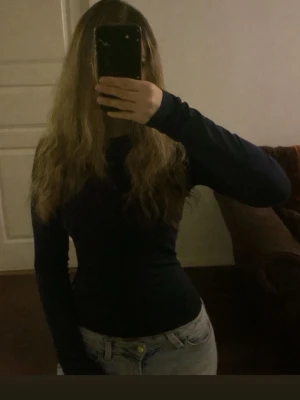 Svart  långärmad topp - Säljer en svart långärmad topp med tight passform. 