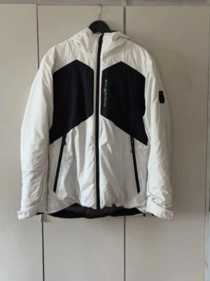 Sail racing jacka  - Sail racing jacka i stl M herr  BESKRIVNING – Svart dunjacka från Sail Racing. Stängs framtill med dragkedja. Två bröstfickor och två framfickor som stängs med dragkedja. En innerficka som stängs med dragkedja. Broderad logotyp på vänster bröst och bak på luvan, patch med logotyp på vänster ärm. Luva med dragsko. Justerbara ärmslut. Jackan är vind och vattenavvisande. ■PFC-fritt DWR membran ■ 70/30 blue sign RDS certifierat dun Skriv för fler bilder! – Köptes för 4,5 k JACKAN ÄR I NYSKICK❤️‍🔥