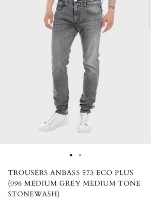Replay Anbass grå jeans - Snygga Replay Anbass jeans i en mellangrå stonewash med klassisk femficksdesign. Jeansen har en slim passform och är tillverkade i mjukt jeansmaterial som ger en bekväm känsla. Perfekta för dig som gillar en modern och stilren look.