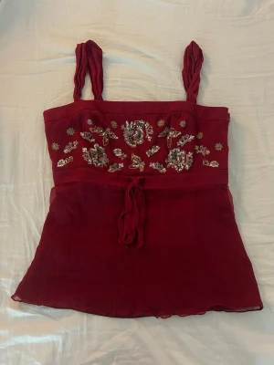 Röd broderad topp - Jättefin röd topp från Monsoon med broderade detaljer i guld och silverpaljetter framtill. Lätt, luftigt tyg som lägger sig supersnyggt!💗
