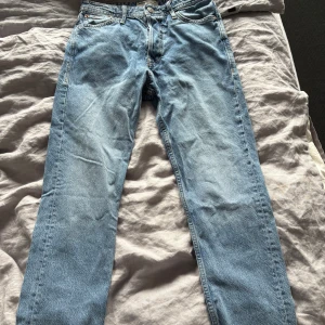 Jack & Jones Loose Chris ljusblå jeans - Ljusblå jeans från Jack & Jones i modellen Loose Chris. Jeansen har en loose passform, klassisk femficksdesign och raka ben. Tillverkade i bomull med snygga slitningar och kontrastsömmar. Perfekta för en avslappnad och trendig look.