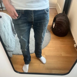 Nudie jeans - Nudie jeans med otrolig wash, jeansen formas fortfarande efter användning, storlek 31/34 men uppsydde till 32 i längd, midja: 42 cm och ytterbenslängd: 104, fickorna är sönder men går att lämna in gratis hos nudie, kom med bud!