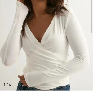 Vit omlottopp från Nelly - Ultra soft wrap top från Nelly. Aldrig använd. Prislapp finns kvar! Säljer då jag glömde returnera i tid.