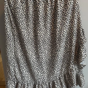 Leopardmönstrad volangkjol från ONLY - Snygg kjol från ONLY med svart och vit leopardmönster. Kjolen har volangdetalj nertill och resår i midjan för en bekväm passform. Perfekt för dig som vill sticka ut med ett trendigt mönster och cool vibe.