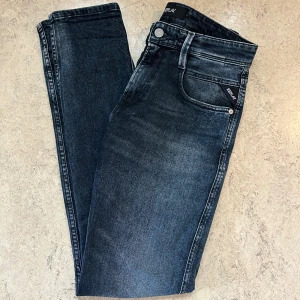 Mörkblå Replay Anbass jeans   - Säljer ett par helt nya mörkblå Replay Anbass jeans i storlek 28/32. Jeansen har en slim passform med klassisk femficksdesign och snygga detaljer vid fickorna. Tillverkade i stretchigt jeansmaterial för extra komfort. Perfekta för dig som gillar en modern och stilren look.