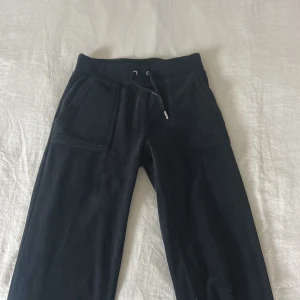Svarta mjukisbyxor Juicy Couture XXS - Svarta mjukisbyxor från Juicy Couture i supermjuk sammet. Byxorna har snörning i midjan, stora fickor fram och bak med tryckknappar. En silverdel är borta (se bild).