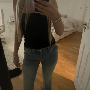 True Religion jeans - Säljer ett par snygga jeans från True Religion med klassiska bakfickor och tydliga sömmar. Jeansen har normal passform och raka ben, tillverkade i mjukt denimtyg. Perfekta för dig som gillar en stilren och trendig look.