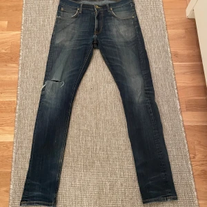 Mörkblå Lee jeans med slitning - Snygga mörkblå skinny jeans med slitning på vänster knä och klassiska fem fickor. Jeansen har en smal passform och lätt tvättade detaljer framtill och baktill. Perfekta för dig som gillar en trendig och avslappnad look.
