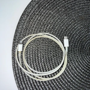 Apple USB-C till Lightning-kabel - Apple USB-C till Lightning-kabel, perfekt för laddning och synkronisering av iPhone, iPad och AirPods. Kabeln är vit och visar tecken på normalt slitage, men fungerar som den ska. Passar till alla enheter med Lightning-port. Längd ca 1 meter.