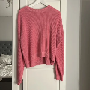Rosa stickad tröja från H&M - Superfin rosa stickad tröja från H&M i storlek M. Tröjan har en loose passform, ribbade muddar och är långärmad. Perfekt för lager på lager och ger en mysig vibe till din outfit.