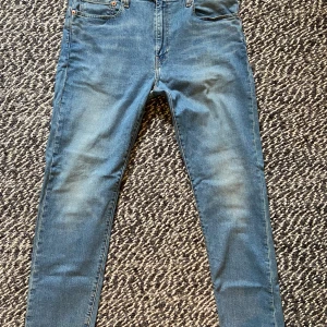 Levi's 512 blå jeans W36 L34 - Säljer ett par klassiska Levi's 512 jeans i ljusblå denim. Modellen har smal passform med raka ben och fem fickor. Snygga kontrastsömmar och läderpatch bak. Perfekta för dig som gillar en modern men tidlös look. Innehåller 2% elastan för lite stretch, vilket gör dem supersköna. Sparsamt använda så vill säga att dem är i nyskick. Kanske använda 2-3 gånger och tvättade en gång.