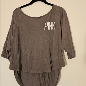 Oversized brun tröja från PINK - Säljer en oversized brun tröja från PINK by Victoria's Secret. Tröjan har trekvartsärm, rund halsringning och längre bakstycke. Stor vit PINK-logga framtill. Storlek XS, men passar även bra till S.