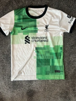 Liverpool Darwin Nunez kit - Ett 23/24 Liverpool bortaställ med Darwin #9 på ryggen. Grönvit med svarta detaljer. Storlek 158 / 13 år