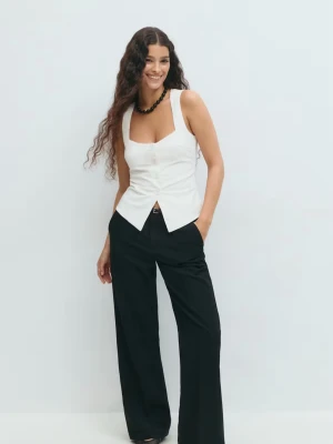 Vit topp från Gina Tricot - Snygg vit korsett-topp från Gina Tricot med breda axelband och markerad midja. Helt oanvänd med prislappen kvar.