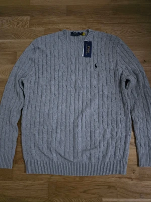 Grå kabelstickad tröja från Ralph lauren  - En grå kabelstickad tröja från Ralph lauren i storlek L för ett jätte billigt pris.