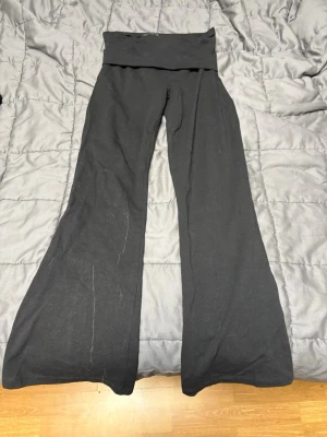 Svarta bootcut mjukisbyxor C 158 - Svarta mjukisbyxor från C i storlek 158. Byxorna har bootcut-ben och bred linning som kan vikas ner. Tillverkade i mjukt och stretchigt material