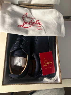 Christian Louboutin mörkblå sneakers - Säljer ett par Christian Louboutin sneakers i färgen navy/blå, helt nya och aldrig använda. Kommer i originalförpacknin.  snabb leverans. Har även svarta skriv för mer info