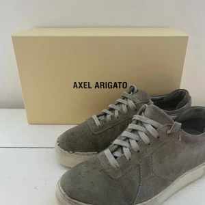 Grå sneakers från Axel Arigato - Snygga grå sneakers från Axel Arigato i mocka.