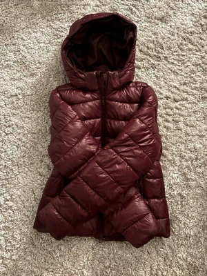 glansig vinterjacka röd stl S - glansig mörk/vinröd vinterjacka i stl S, helt ny endast testad! super skön och passar till vinter/höst💞