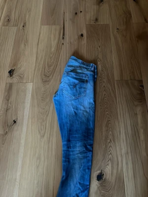Dondup w33 - Säljer dessa blåtvättade jeans ifrån dondup.jeansen har en slim fit passform med fåtal slitningar bla på bakfickan. Säljer dem för priset därav defekten som kan synas på bild 4, denna defekt kan såklart lagas kan ta extra betalt för att laga det. Hör av er vid frågor angående jeansen eller om fler bilder!