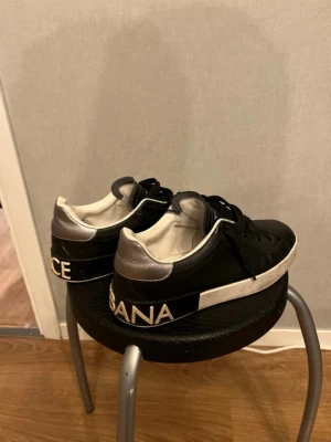 Dolce & Gabbana svarta sneakers - Tjena säljer ett par feta Svarta sneakers från Dolce & Gabbana med vita och silverfärgade detaljer. Skorna har tydlig logga bak på hälen och på sulan, svart snörning och vit sula.