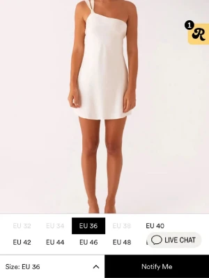 Vit oneshoulder kortklänning med knyt - Supersnygg vit kortklänning med oneshoulder och öppen rygg. Klänningen har breda axelband och ett dekorativt knyt i ryggen som ger en unik look. Perfekt för dig som vill sticka ut och känna dig extra chic. Kan även tänka mig byta till en stl större om någon är intresserad! Obs går inte att få tag på längre. Prislapp kvar och är endast testad, säljer då den va för kort för min smak💕