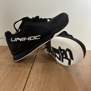 Extremt Sällsynta Unihoc Innebandy Skor strl 41 - Säljer ett par sällsynta UA Charged Commit TR 3 träningsdojor (unihoc variant) då jag slutade köra innebandy för 3 år sedan och dojjorna bara har stått på hyllan.  Som man ser på bilderna är de i toppskick, så gott som nya. Är osäker på om jag överhuvudtaget ens använt dem. De är perfekta för inomhussport eller träning överlag. Snygg och sportig design med bekväm passform. Kvitto och kartong (se bilder) medföljes. Nypris: ”?” hittar inte denna version på marknaden. Köpt för 899:-