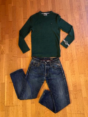 Replay jeans  - Säljer ett par Replay Grover jeans i klassisk blå tvätt med snygga slitningar och kontrastsömmar. Jeansen har raka ben, fem fickor och detaljer som nitar och Replay-lapp bak i midjan. Perfekta för dig som gillar en avslappnad men stilren look.