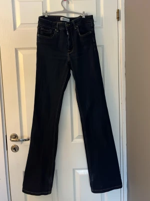 Mörkblå bootcut jeans från Zara - Säljer dessa jeans från Zara i strl 38. Jeansen är slitna o skadade längs ner därav priset. Sköna jeans som utöver benen är i bra skick.