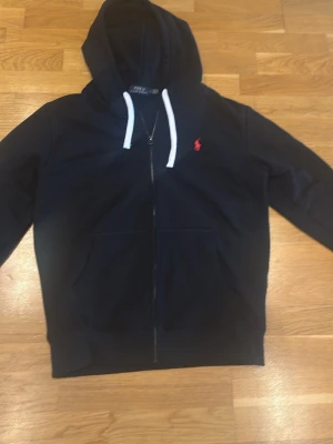 Svart hoodie Ralph Lauren. L - Säljer denna snygga tröjan eftersom jag har vuxit ur den. Den har använts på ett ansvarsfullt sett. Skriv om fler bilder och priset kan diskuteras 