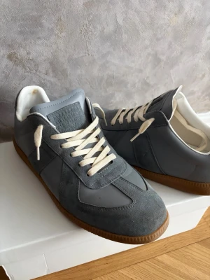 Maison margiela grå st 43 - Ett par fina skor från maison margiela i storlek 43, skick är 7,5/10, lite slitage på innersulan, annars är de i bra skick och har tagit hand om de. De kommer med sin låda och kvitto (ÄKTHETSBEVIS), innersulan är 27 cm. skriv om du har någon fråga eller sådant