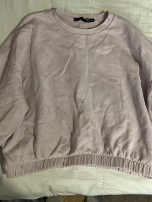 Kort tjockare tröja med resor  - Kort tjockare tröja med resor nertill med en fin passform. Fin ljus lila färg 