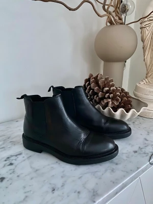 Vagabond svarta boots dam stl 36 – mycket bra skick - Säljer ett par svarta boots från Vagabond i storlek 36, dam. Stilren och tidlös modell som funkar lika bra till vardag, jobb, AW eller en kväll ute. Lätta att matcha och bekväma att bära – skor man faktiskt använder, inte bara har i garderoben. Skorna är använda men i mycket bra skick, med fint helhetsintryck och gott om liv kvar. Vagabonds välkända kvalitet i både material och passform. Nypris ca 1600 :- Pris: 450 :- 