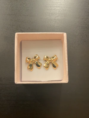 Gudliga rosett örhängen  - Jag säljer ett par guldiga rosett örhängen som har använts fåtal gånger. Dom kommer att rengöras ordentligt innan dom säljs. Dessa är inte i äkta guld men har hålt länge skulle jag säga. 💕🎀