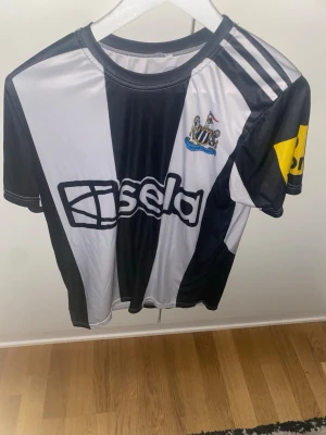 Newcastle United matchtröja Isak 14 Fejk  - Säljer en svartvit randig Newcastle United matchtröja med Isak och nummer 14 på ryggen.  Är fejk men är väldigt snygg 😻 