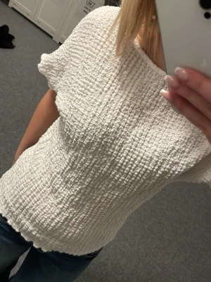 Vit ribbad topp lager157 - En vit ribbad topp från 157 i storlek XS. Toppen har korta ärmar, rund halsringning och ett stretchigt material. Inte mycket använd.